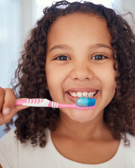 Happy young girl holding her toothbrush