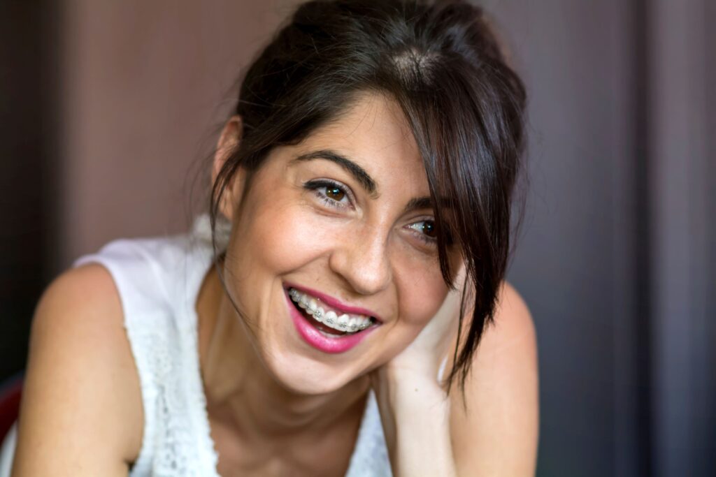 Woman with dark hair and braces smiling